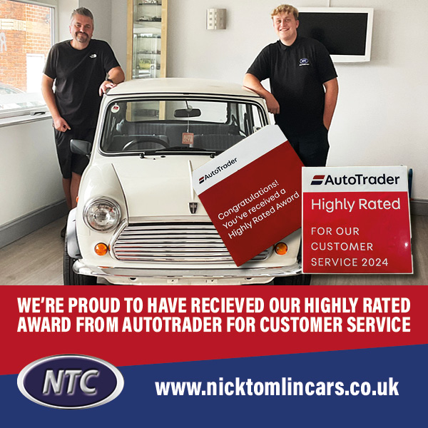 "Nick and Ellis Tomlin, father and son owners of Nick Tomlin Cars, stand proudly beside a classic white Mini inside their showroom. A banner highlights their 2024 AutoTrader Highly Rated Award for outstanding customer service. The Nick Tomlin Cars logo and website URL are displayed at the bottom."